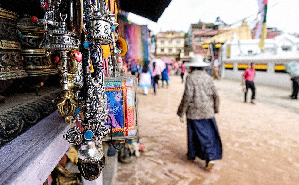 woman waking away from the hanging decor at an open air shop